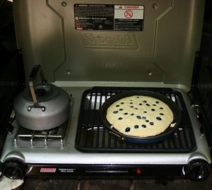 breakfast of blueberry pancakes and hot water boiling for tea or coffee on our Coleman stove