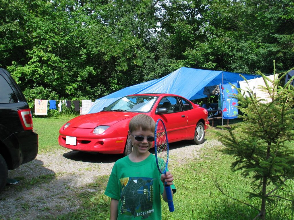 picture of a young boy in a campsite at Emily Provincial Park with a badmiton racket