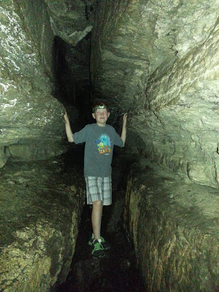picture of a boy in a cave wearing a headlamp
