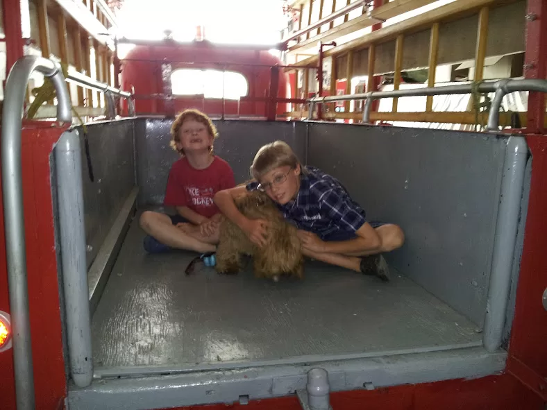 picture of two boys and a dog in the back of an old firetruck in Parry Sound Ontario near Killbear Provincial Park