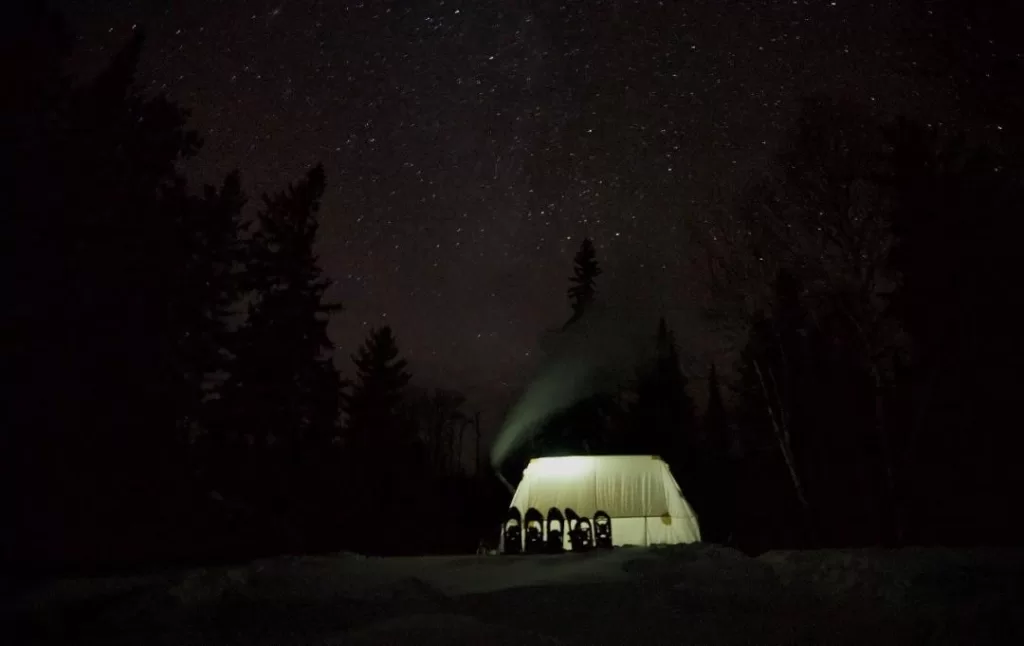 picture of a hot tent taken while winter camping at night