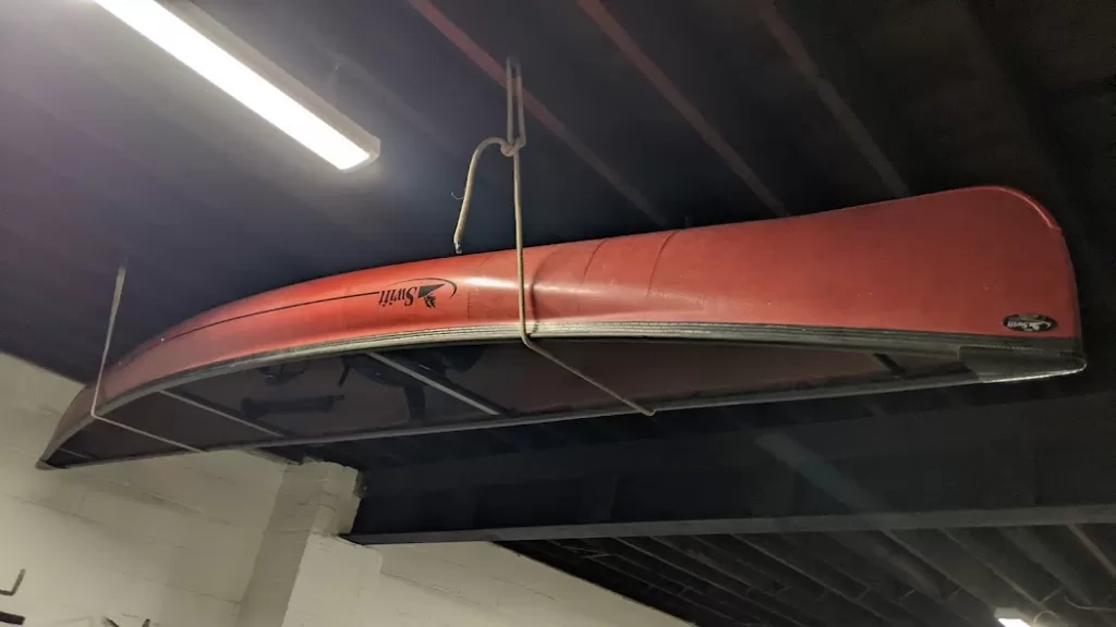 picture of a red keywadin swift solo canoe hanging upside down in storage in the garage